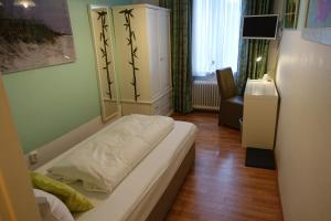 a bedroom with a bed and a chair in a room at Hotel Villa Konstanz in Berlin