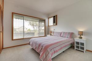 a bedroom with a bed and a large window at Stradbroke in Metung