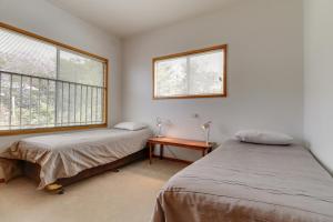 a bedroom with two beds and a table and two windows at Stradbroke in Metung +15 photos