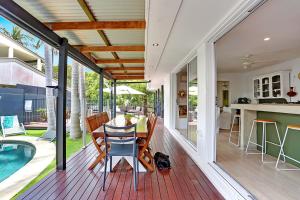 a patio with a table and chairs and a swimming pool at Birdsong in Sunrise Beach