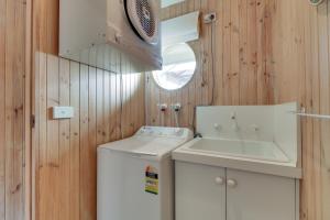 Un baño con lavadora y lavabo. en Casuarina, en Metung