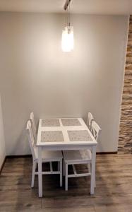 a white table and chairs in a room at Przytulny Apartament w Gołdapi in Gołdap