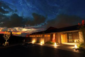 a building with lights on the side of it at night at Umino Ryotei Okinawa Nakamasou in Onna