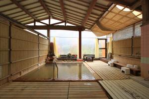 um quarto amplo com uma piscina de água num edifício em Ramune Onsen Senju no Sato em Kirishima