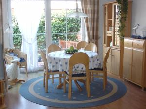 a dining room with a table and chairs and a kitchen at Ferienwohnung Kiebitznest in Borkum