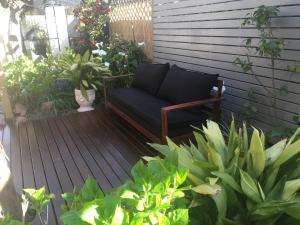 a blue couch sitting on a deck with plants at bluebird cottage in Angaston