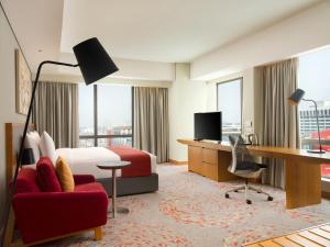 a hotel room with a bed and a desk and a computer at Holiday Inn & Suites Jakarta Gajah Mada, an IHG Hotel in Jakarta