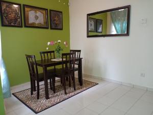 een eetkamer met een tafel en stoelen en een spiegel bij Muslim Dinaim Homestay in Tanjung Malim