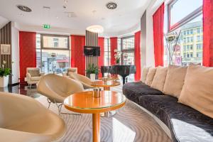 - un salon avec un canapé et des tables dans l'établissement Best Western City Hotel Braunschweig, à Brunswick