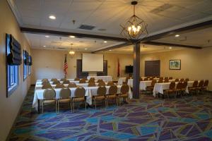 a conference room with tables and chairs and a screen at Best Western Plus Morristown Conference Center in Morristown