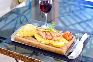 a plate of food with meat and cheese and a glass of wine at Harrys Hotel Bar & Restaurant in Pattaya