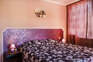 a bedroom with a bed with a purple headboard at Feniks Apartments in Nesebar