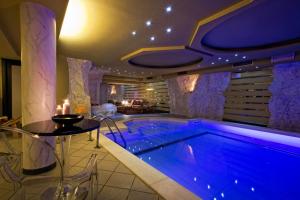 a swimming pool in a house with a table and a table at Hotel Regina in San Martino di Castrozza