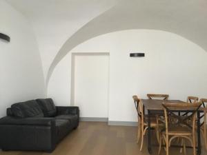 a living room with a black couch and a table at Les quatre provinces d'Irlande in Saint-Amant-Tallende