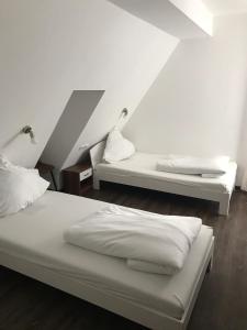 - une chambre avec 2 lits et des draps blancs dans l'établissement Gasthof Bräuhäusle, à Baienfurt
