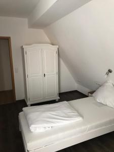 Gasthof Bräuhäusle في Baienfurt: غرفة نوم مع سرير أبيض وخزانة