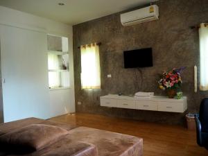 sala de estar con TV en la pared en NawiengkaeRiverview Resort, en Mukdahan