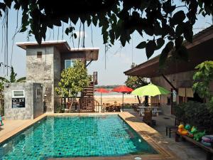 a swimming pool in front of a house at NawiengkaeRiverview Resort in Mukdahan