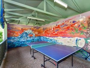a ping pong table in a room with a mural at Allamanda 37 in Long Jetty +2 photos