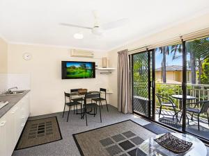 a kitchen and living room with a table and chairs at Allamanda 37 in Long Jetty