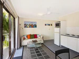 a living room with a couch and a table at Allamanda 37 in Long Jetty