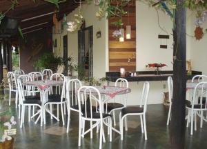 a group of white tables and chairs in a restaurant at Pousada Recanto Lara in Olímpia