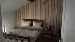 プロブディフにあるGuest Rooms Filipopolの木製の壁のベッドルーム1室(ベッド1台付)