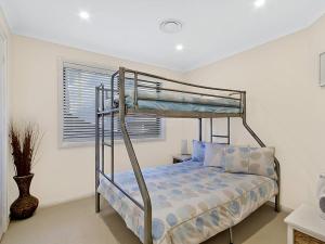 a bedroom with a bunk bed and a window at Beach Front Luxury in The Entrance