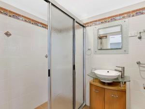 a bathroom with a shower and a sink at Beach Front Luxury in The Entrance