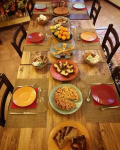 a long wooden table with plates of food on it at B&B La Dimora del Capitano in Fabriano +35 photos