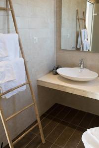 a bathroom with a towel ladder and a sink at Niovi Boutique Apartments in Afitos