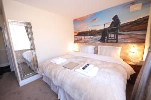 a bedroom with a bed with a mirror and a laptop at Toulson Court in Scarborough