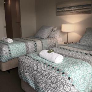 two beds sitting next to each other in a room at 16 Seine Bay Apartment in Augusta