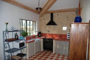SabranにあるMas de Faviéretteのキッチン(赤いカウンター、コンロ付)