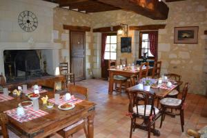 comedor con mesas de madera y chimenea en Maison d'Hôtes La Chouanniere, en Brion