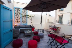 a patio with a couch and an umbrella at Backstage Boutique Music Themed Townhouse in Sliema