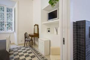 a living room with a tv and a table with a chair at B&B Domus Aurea in Rome