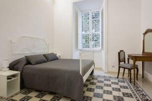 1 dormitorio con cama, escritorio y ventana en B&B Domus Aurea, en Roma