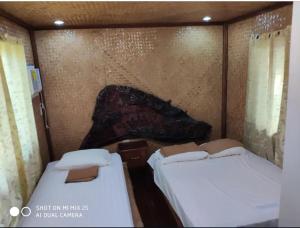 2 łóżka w małym pokoju ze ścianą w obiekcie Marianne Port Barton w mieście San Vicente