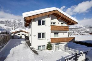 a house with snow on the roof at Appartments Weiss in Westendorf