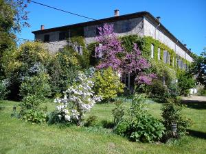 a garden of flowers in front of a building at Domaine du Peyron in Quintenas