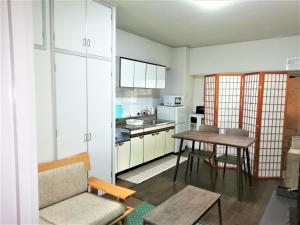 a living room with a table and a kitchen at Near Tram Apartment Okayama in Okayama