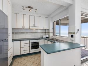 a kitchen with white cabinets and a view of the ocean at Dolphin Court 4 in The Entrance
