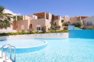 a swimming pool in front of a house at Plakias Panorama Homes in Plakias