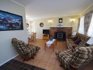 a living room with two couches and a fireplace at Fravent house in Toukley