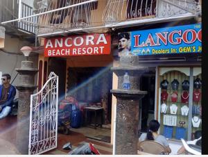 a store front of a beach resort with people sitting in front at Stay at Tito's Lane in Marmagao