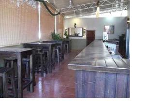 um bar com mesas de madeira e bancos numa sala em Stay at Tito's Lane em Marmagao