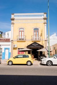 um carro amarelo estacionado em frente a um edifício em Dream Residence em Olhão