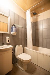 a bathroom with a toilet and a tub and a sink at Litlabjarg Guesthouse in Hrafnabjorg