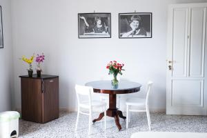 un tavolo con sedie bianche e un vaso di fiori sopra di Vittoria Guest House Battipaglia a Battipaglia